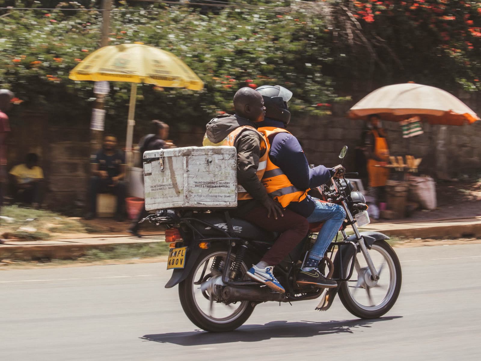 A delivery rider on a motorbike with a delivery box