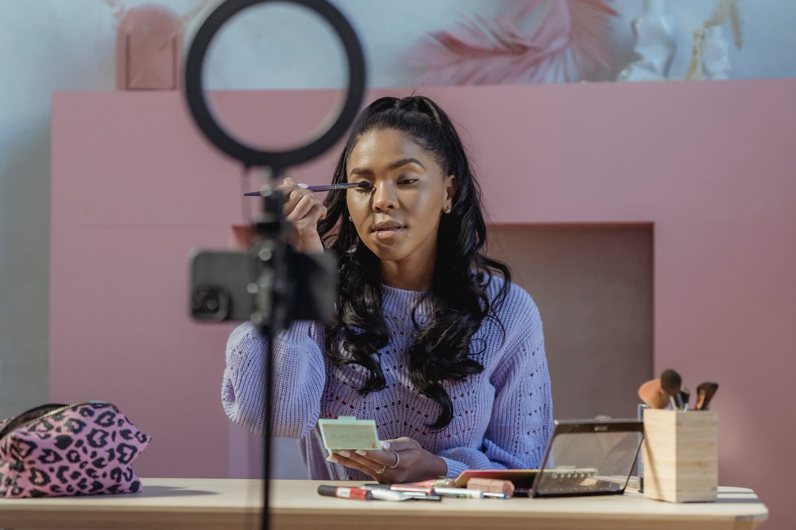 A content creator recording a video on a phone with a ring light